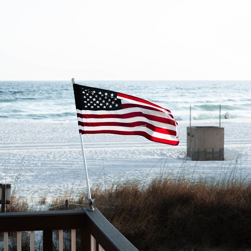 a flag on a railing by the ocean