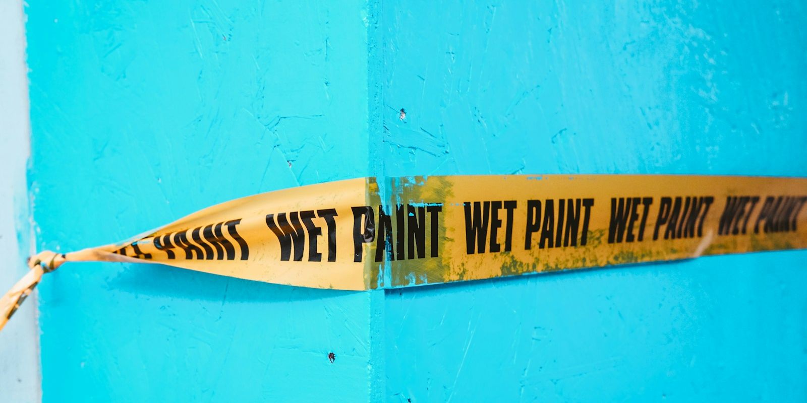 a yellow and black sign on a blue wall